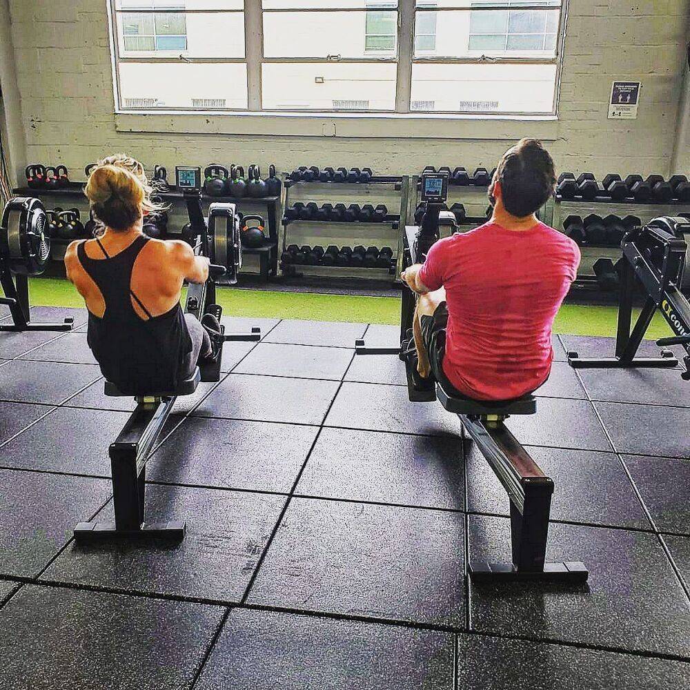 Members rowing side by side during a group class
