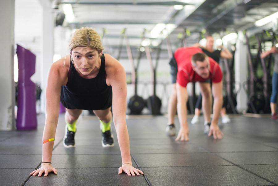 Members holding a plank together on the Petworth Fitness floor