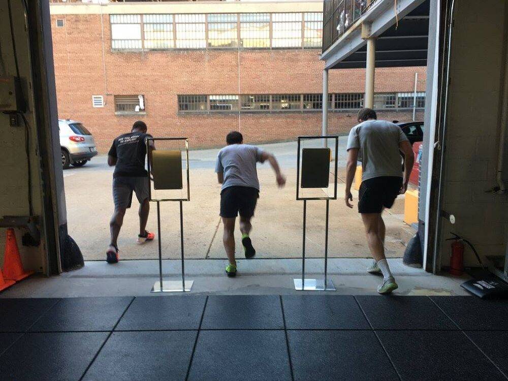 Members running out the garage door for a Run workout